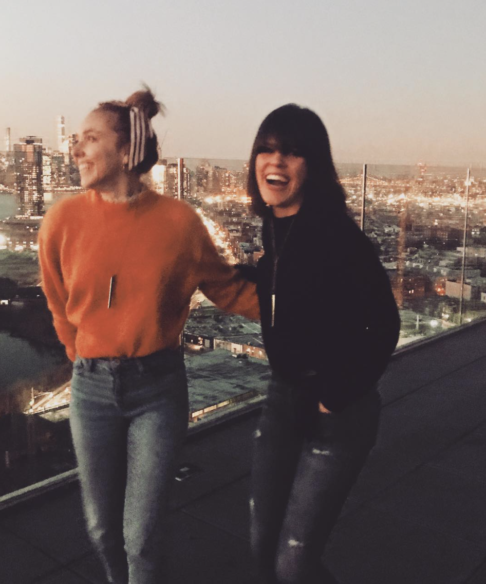 Two individuals on a roof, laughing, both wearing Vespers.